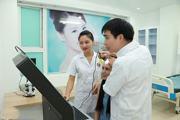 Bác sĩ Tuấn soi và kiểm tra tình trạng tóc khách hàng trước khi đưa ra phác đồ điều trị